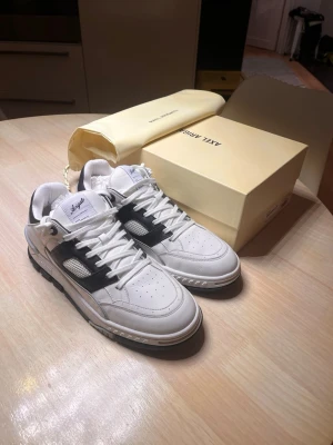 Axel Arigato Area Lo sneakers  - Axel Arigato Area Lo sneakers strl 46, använda kanske 6 gånger så dem är som nya, väldigt få tecken på användning. Lådan och skopåsen finns kvar, påsen aldrig använd. Säljer pga att dem var för stora. Nypris 3400
