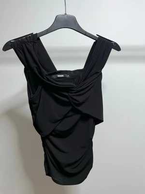 Svart draperad linnetopp från Bik Bok - svart linnetopp från Bik Bok med breda axelband och snygg drapering framtill. Endast testad