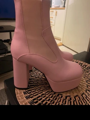 Rosa platåstövletter med chunky klack - Säljer ett par snygga rosa Lamoda stövletter med hög platå och chunky blockklack. Helt nya. Litet märke på ena klacken som inte syns tydligt
