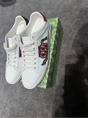 Gucci ace orm - Säljer ett par vita Gucci ace skor. Storlek 42. Mycket bra skick. Låda, påse och lappar ingår. Pris kan diskuteras vid snabb affär