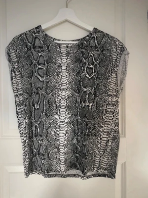Svartvit topp med ormmönster - Se bilder för skick 