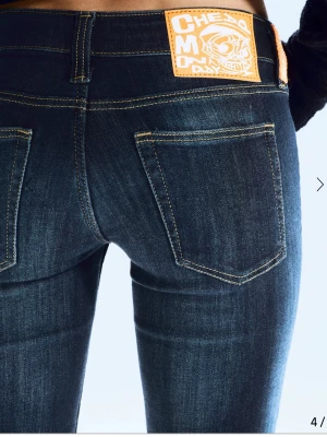 Mörkblå bootcutjeans från Cheap Monday - Snygga mörkblå bootcutjeans från Cheap Monday med klassisk femficksdesign och kontrastsömmar. Jeansen har en cool patch baktill i orange och är tillverkade i stretchigt denim för en bekväm passform.