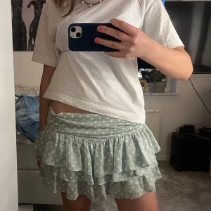 Prickig volangkjol - Säljer en ljusgrön kortkjol med vita prickar och dubbla volanger. Perfekt nu inför sommaren!!!😽