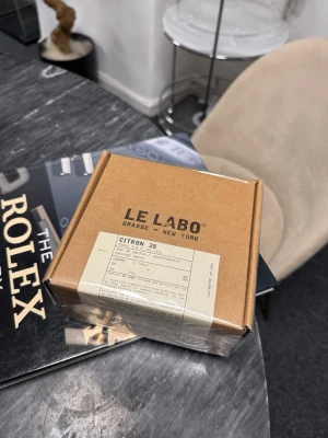 Le Labo Citron 28 parfym - Le Labo Citron 28 är en exklusiv parfym i en stilren brun kartong med tydlig etikett. Märket är känt för sina unika doftkombinationer och minimalistiska förpackningar. Perfekt för dig som gillar fräscha, citrusbaserade dofter och vill ha något som sticker ut.