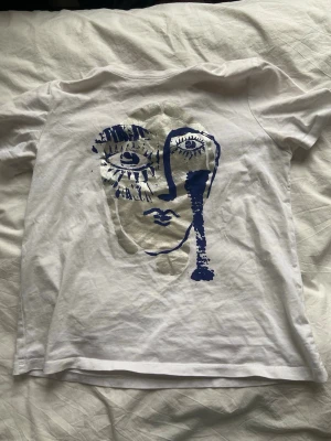 Vit t-shirt med konstnärligt ansikte - Säljer denna snygga t shirt i storlek M, men passar mig perfekt som oftast alltid bär xs/s❣️❣️❣️