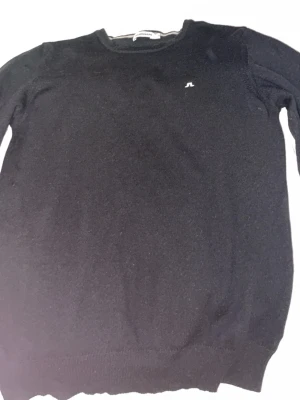 Svart stickad tröja från J.Lindeberg - Klassisk svart stickad tröja från J.Lindeberg. Storlek M men den är mer som en Xs PRIS KAN DISKUTERAS!!! 