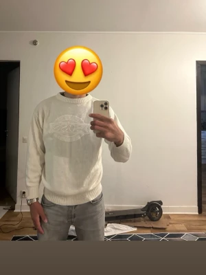 Vit stickad tröja från BOSS - Snygg vit stickad tröja från BOSS med broderad logga framtill. Tröjan har rund halsringning, ribbade muddar vid ärmslut och nederkant samt en relaxed fit. Perfekt för dig som vill ha en clean och stilren look.