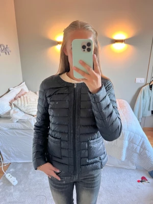 Svart pufferjacka från JOTT - Säljer en svart pufferjacka med rund halsringning och dragkedja framtill från JOTT. Jackan har en stilren, quiltad design och två fickor på sidorna. Materialet är lätt och ger bra värme. Ny pris 2600 men säljer för 1900 ( andvänd ett få tal gånger 💗💗