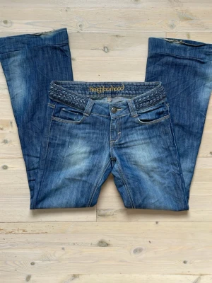 Lågmidjade bootcut jeans  - Lågmidjade jeans i strl 27. Innerbenslängd ca 78cm, midja rakt över ca 36,5cm.  