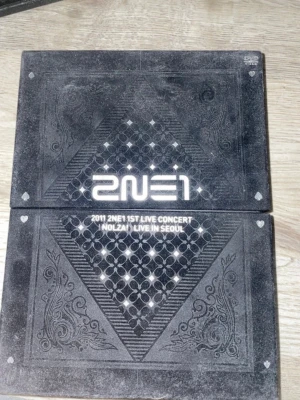 2NE1 1st Live Concert NOLZA fotobok - Säljer en exklusiv fotobok från 2NE1:s första livekonsert NOLZA i Seoul 2011. Boken har svart omslag med holografiska och röda detaljer, samt spadermotiv och mönster. Perfekt för fans av K-pop och samlare.