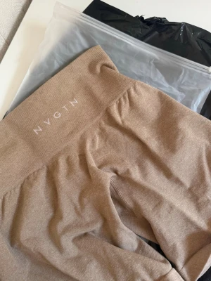 Beige seamless shorts från NVGTN - Snygga beige seamless shorts från NVGTN med hög midja och bred resår. Tillverkade i ett stretchigt och mjukt material som sitter skönt och formar sig efter kroppen. Perfekta för gymmet eller andra träningspass. Aldrig använda. Lapp kvar 