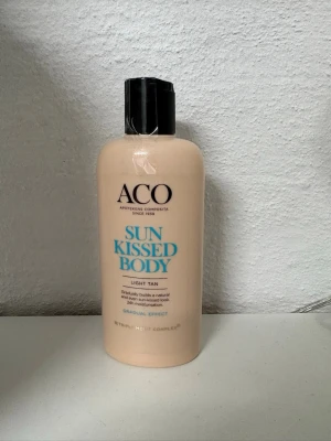 ACO Sun Kissed Body Light Tan - ACO Sun Kissed Body Light Tan är en kroppslotion som gradvis ger en naturlig solkysst ton. Flaskan är beige med svart lock och rymmer 200 ml. Innehåller Triple Moist Complex för intensiv återfuktning och passar dig som vill ha en lätt brun utan sol-effekt. Helt oanvänd!