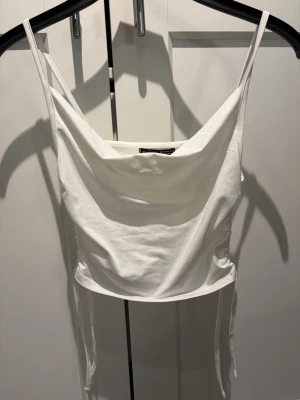 Vit linne med snörning - En vit linnetopp i storlek S. Toppen har tunna axelband, draperad urringning och snörning i sidorna för en snygg passform. Perfekt till sommaren och enkel att styla med olika outfits 🤍🌺