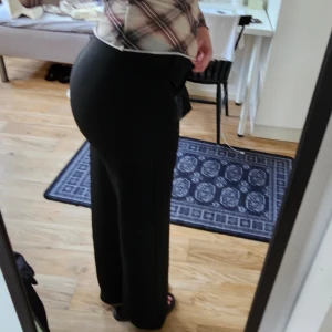 Svarta kostymbyxor Nelly - Säljer ett par svarta kostymbyxor med låg midja och raka ben från Nelly. Byxorna har en klassisk look och passar perfekt till skjorta eller t-shirt. Materialet är mjukt och följsamt. 