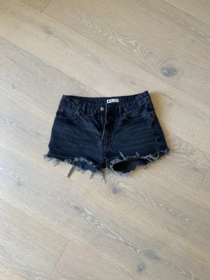 Jeansshorts  - Säljer ett par svarta jeansshorts med rå, fransig kant  Från Ginatricot storlek xs/34🦋