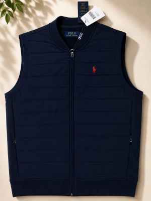 Mörkblå dunväst från Polo Ralph Lauren - Stilren mörkblå dunväst från Polo Ralph Lauren med rakt snitt, dragkedja framtill och två sidofickor med dragkedja. Västen har det klassiska röda Polo-logot broderat på bröstet och quiltad design. Perfekt för lager-på-lager och snygg till jeans.