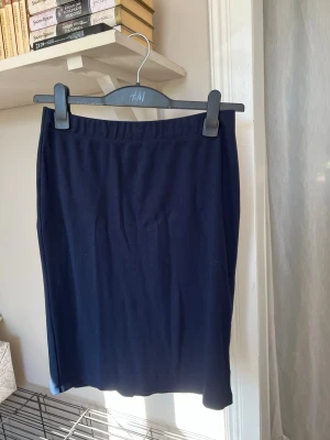 Mörkblå trikåkjol - Mörkblå, rak kjol med resår i midjan. 