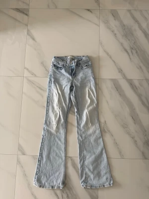 Ljusblå bootcut jeans  - Ljusa lågmidjade jeans från Gina Tricot. Lite nertrampade men inget som märks av vid användning. 