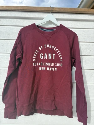 Vinröd sweatshirt från Gant -  vinröd sweatshirt från Gant med vit text på bröstet (strlk 176 -xs) 