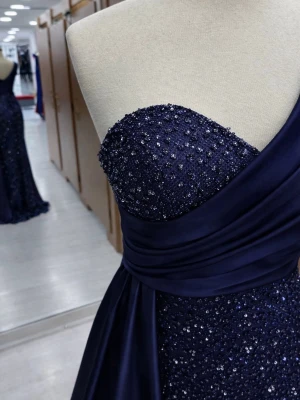 Marinblå glittrig långklänning oneshoulder - Elegant marinblå långklänning med glittriga detaljer och en axelbandslös design på ena sidan. Klänningen har en vacker drapering över bysten och midjan samt en oneshoulder-skärning. Perfekt för bal eller festliga tillfällen. Jag köpte den utomlands. Har använt vid 1 tillfälle