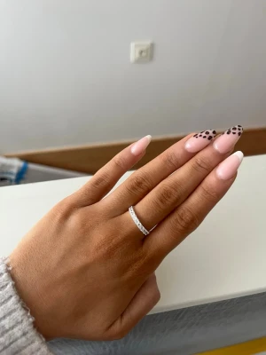 Äkta silver ring  - Äkta silver ring med rad av stenar i Cubic Zirconia. Ringen är i sterling silver 18 karat guld. Den är i storlek 17, vilket motsvarar en S. Den sitter lite löst på mitt ring finger men perfekt på mitt långfinger. Finns inga defekter på ringen.