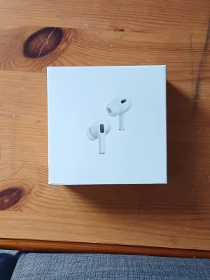Apple AirPods Pro 2nd Gen - Apple AirPods Pro 2nd generation i vit färg med trådlöst laddningsetui, silikonproppar i olika storlekar och USB-C laddningskabel. Har också Active Noise cancellation