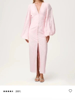 Ljusrosa långklänning med puffärm - Jättefin rosa långklänning från adoore, endast använd en gång och finns inga defekter förutom att två eller tre knapparna längst ner är borta men det är inte som synns eller som man tänker på, säljer för att den är för liten