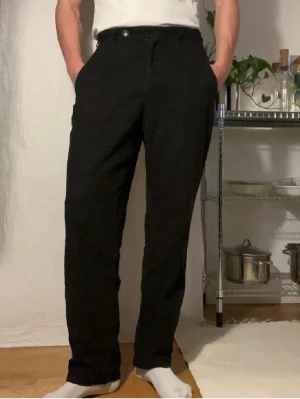 Svarta linebyxor L'Homme Rouge - Snygga svarta kostymbyxor från L'Homme Rouge med rak passform och klassisk midja. Byxorna har diskreta fickor och stilren design, sitter skönt och luftigt, ny pris 1900 och min pris 170