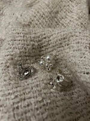 Tre silvriga ringar  - Tre ringar i silverfärgad metall. En av ringarna har vita pärlor. Aldrig använda 