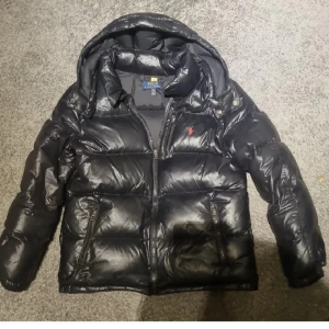 Svart dunjacka från Polo Ralph Lauren - svart dunjacka från Polo Ralph Lauren i bra skick den är äkta (kan scanna den i nacken) går inte ner mycket i pris. Ja är 160 och den sittter perfekt på mig