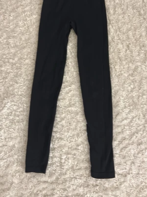 Svarta basic leggings - Säljer ett par svarta träningsbyxor med tight passform och hög midja. De är stretchiga, perfekta till oversized tröjor eller hoodies. Materialet känns som bomullsmix med lite elastan för extra komfort.