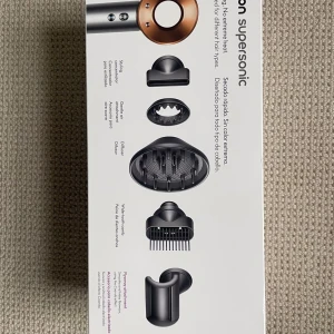 Dyson Supersonic hårfön koppar/silver - Dyson Supersonic hårfön i koppar och silver med fem olika stylingmunstycken. Modern och stilren design med rund form och metallfinish. Perfekt för att torka och styla alla hårtyper utan extrem värme. Levereras med diffuser, stylingkoncentrator och kammunstycke.