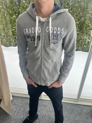 Grå zip hoodie med tryck - Snygg grå zip hoodie från okänt märke. Bra kvalitet. Strl M. Personen på bilden är 183 cm lång. Skicka gärna prisförslag. Fraktas dagen efter köp