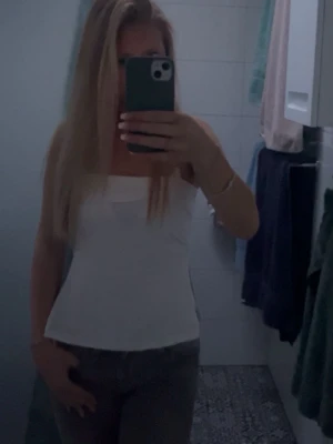 Vit ärmlös linnetopp - Snygg vit linnetopp med fyrkantig urringning och figurnära passform. Perfekt att styla med jeans eller kjol för en clean och fräsch look. Enkel och stilren design som passar till många olika outfits.