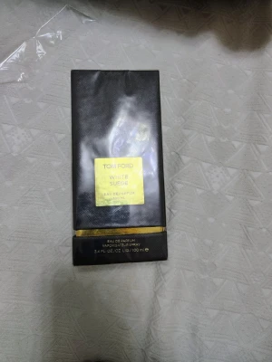 Tom Ford White Suede EdP 100 ml oöppnad  - Lyxig parfym från Tom Ford, White Suede Eau de Parfum i 100 ml flaska. Förpackningen är svart med gulddetaljer och har en elegant, modern design. Perfekt för dig som gillar exklusiva dofter och vill ha något unikt i parfymhyllan.