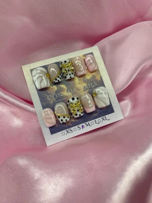 Bijou (M);Short Ballerina - Snygga press-on naglar från Vonshia Nails i mixade designer. Setet har rosa, vita och svarta färger med coola prickar, abstrakta linjer och gulddetaljer. Några naglar har 3D-guldrosetter och andra har trendiga swirl-mönster. Perfekt för dig som vill sticka ut med dina naglar!