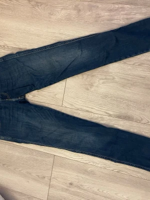 Mörkblå Replays  - Säljer ett par mörkblå replay jeans som är smoking vid benen och normal vid midjan. Dem har blivit för små och är i nyskick bortsett från lappen vid midjan på baksidan som är sönder. Skriv vid info och pris går att diskutera