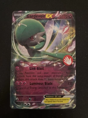 Pokémonkort Gardevoir EX holo - Säljer ett Gardevoir EX holo Pokémonkort med 170 HP. Kortet har färgstark design med gröna, rosa och gula detaljer samt glittrig yta. Det är ett samlarkort från Pokémon Trading Card Game och har attacker som Link Blast och Luminous Blade. Perfekt för samlare eller TCG-spelare.