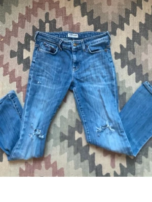 Blå jeans med slitningar från Lee - Inte mina bilder!!! Säljer ett par blå jeans från Lee med slitningar på knäna och klassisk femficksmodell. Säljer vidare då dom inte passade mig, midjemått:35 innebenslängden:72. Kan tyvärr inte ta några bilder på. 
