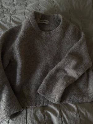 Beige stickad tröja Samsøe Samsøe - Mysig beige stickad tröja från Samsøe Samsøe med rund halsringning och lång ärm. Tröjan har en fluffig, mjuk struktur och är perfekt för kyliga dagar. Passar till både jeans och kjol för en avslappnad look.