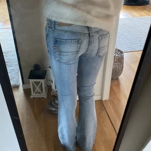 American Eagle low waist jeans - Säljer dessa skitsnygga American eagle low waist jeans. Säljer då de är lite för stora i midjan för mig. Återpublicerad annons (därav ej mina bilder) men tjejen på bilden är 1,75cm lång (passade även mig i längd som är 167). Ungefär 36cm rakt över midjan och 79 innerbenslängd!Jeansen är i topp skick och inga synliga defekter alls. Två små hål med en tråd igenom på insidan för att knyta åt midjan men det är absolut ingenting som märks av på resten av jeansen och man kan enkelt bara ta ut tråden ❣️
