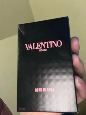 Valentino Uomo Born In Roma 100ml - Valentino Uomo Born In Roma är en lyxig herrparfym i en snygg svart kartong med rosa text. Flaskan rymmer 100 ml och har en modern, edgy design med nitar. Perfekt för dig som gillar exklusiva och trendiga dofter. Andvänd för att testa den