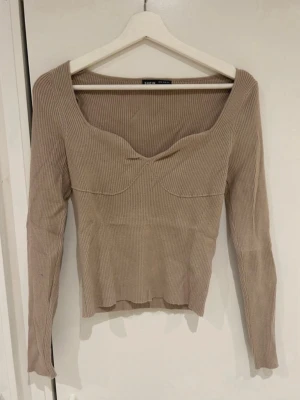 Beige tröja  - Stickad tröja med V-ringning 