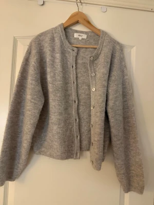 Grå kofta från Gina Tricot - Mysig grå kofta från Gina Tricot. Koftan har rund halsringning, knappar framtill och ribbade muddar vid ärmslut och nederkant. Perfekt för lager på lager och enkel att matcha med olika outfits och perfekt nu inför det kyliga vädret men kan även passa bra för sena sommarkvällar💕💕💕