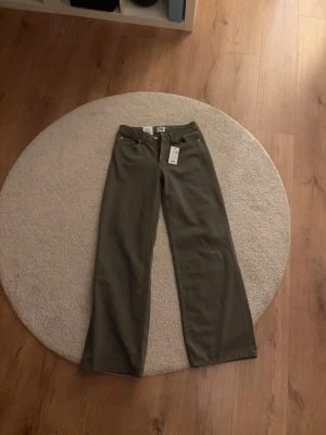 Olivgröna raka jeans XS - Snygga olivgröna jeans från lager157 modellen heter Optiwide full längd. Jeansen har klassisk femficksdesign och bälteshällor. Perfekta för dig som gillar en avslappnad men trendig stil.