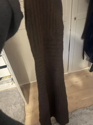 Brun ribbad långkjol adoore - Mysig brun långkjol i ribbat stickat material. Kjolen har en rak passform och är perfekt för dig som gillar en enkel men ändå trendig look. Passar till både sneakers och boots.
