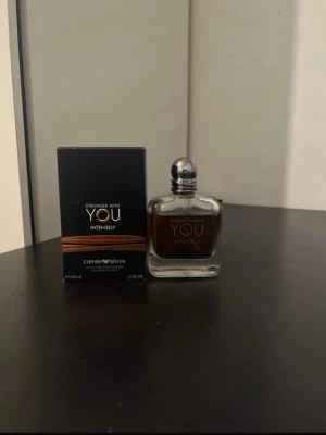 Emporio Armani Stronger With You Intensely - Emporio Armani Stronger With You Intensely är en elegant herrparfym i en stilren, genomskinlig glasflaska med rundade former och silverfärgad kork. Doften har en djup bärnstensfärg och kommer med originalkartong i svart med bronsdetaljer.