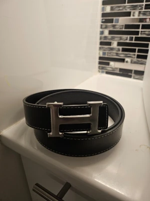 Svart H bälte - Snyggt svart H bälte med nytt skick. Passar till väldigt många outfits. DM vid intresse!