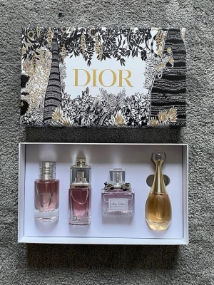 Dior parfymset 4x30ml - Lyxigt parfymset från Dior med fyra olika dofter: J'adore, Miss Dior Blooming Bouquet, Dior Addict och Joy. Flakongerna är i glas med eleganta detaljer i guld och silver. Kommer i en exklusiv vit presentask med svart och guldmönster. Perfekt för dig som vill testa flera ikoniska Dior-dofter. Aldrig använda. Skriv gärna!
