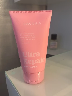 L'Acuila Ultra Repair hårinpackning - Ultra Repair Hair Masque från L'Acuila i en rosa tub. Intensiv hårinpackning som stärker och reparerar håret, gör det silkeslent och är skonsam mot hårbotten. Perfekt för dig som vill boosta håret med extra vård. HELT NY